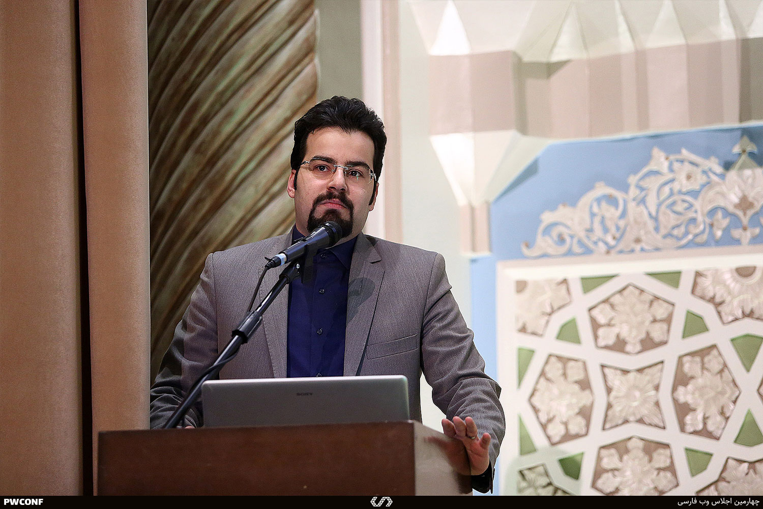 Dana Bina speaking at a podium during an international web and technology conference keynote session